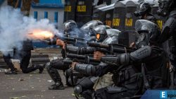 Personel kepolisian menembakkan gas air mata ke arah massa