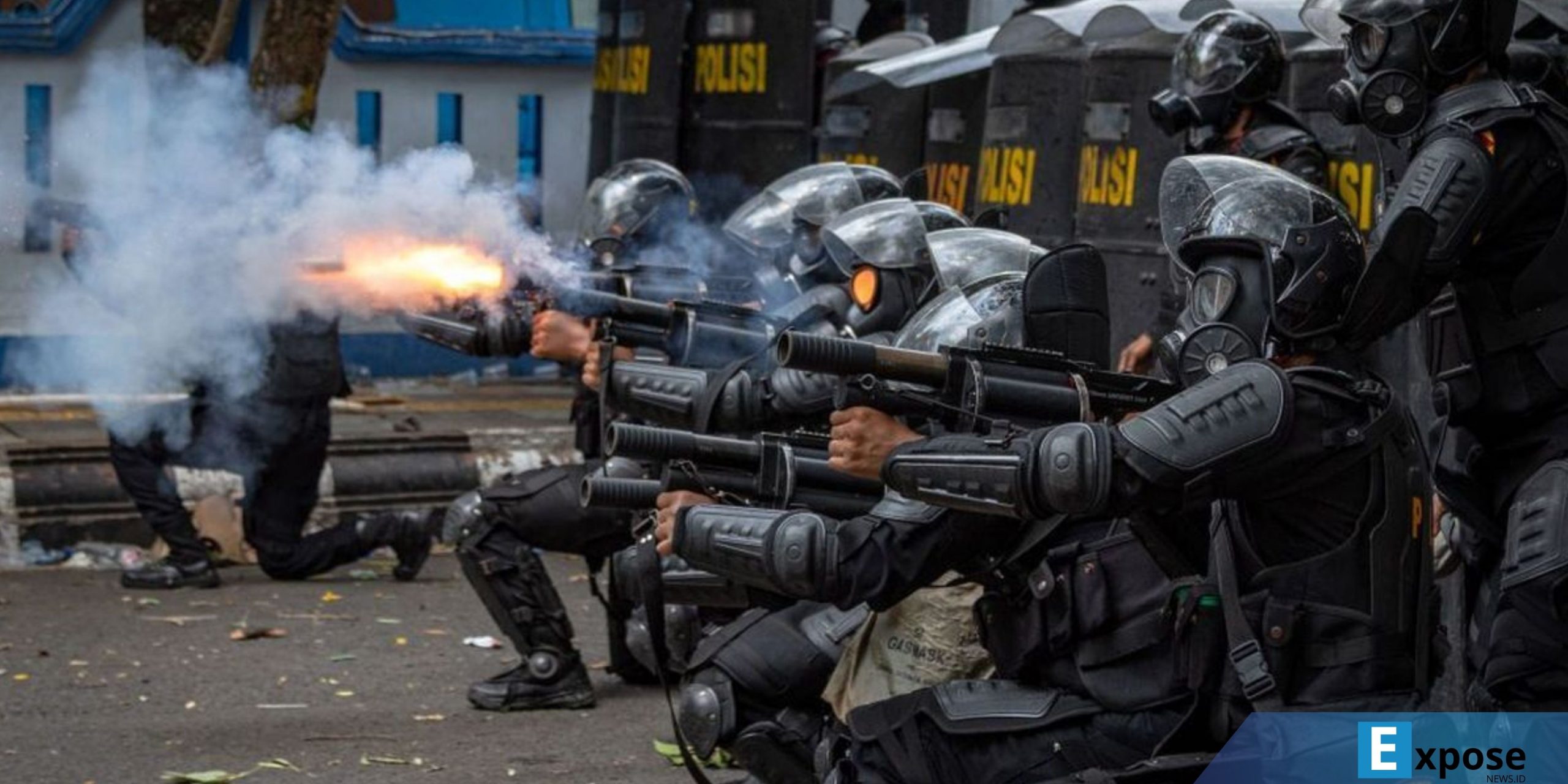 Personel kepolisian menembakkan gas air mata ke arah massa