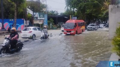 Pengendara terlihat menerobos genangan air yang menutup Jalan Dr. Mansyur, Kelurahan Padangbulan, Kecamatan Medan Selayang