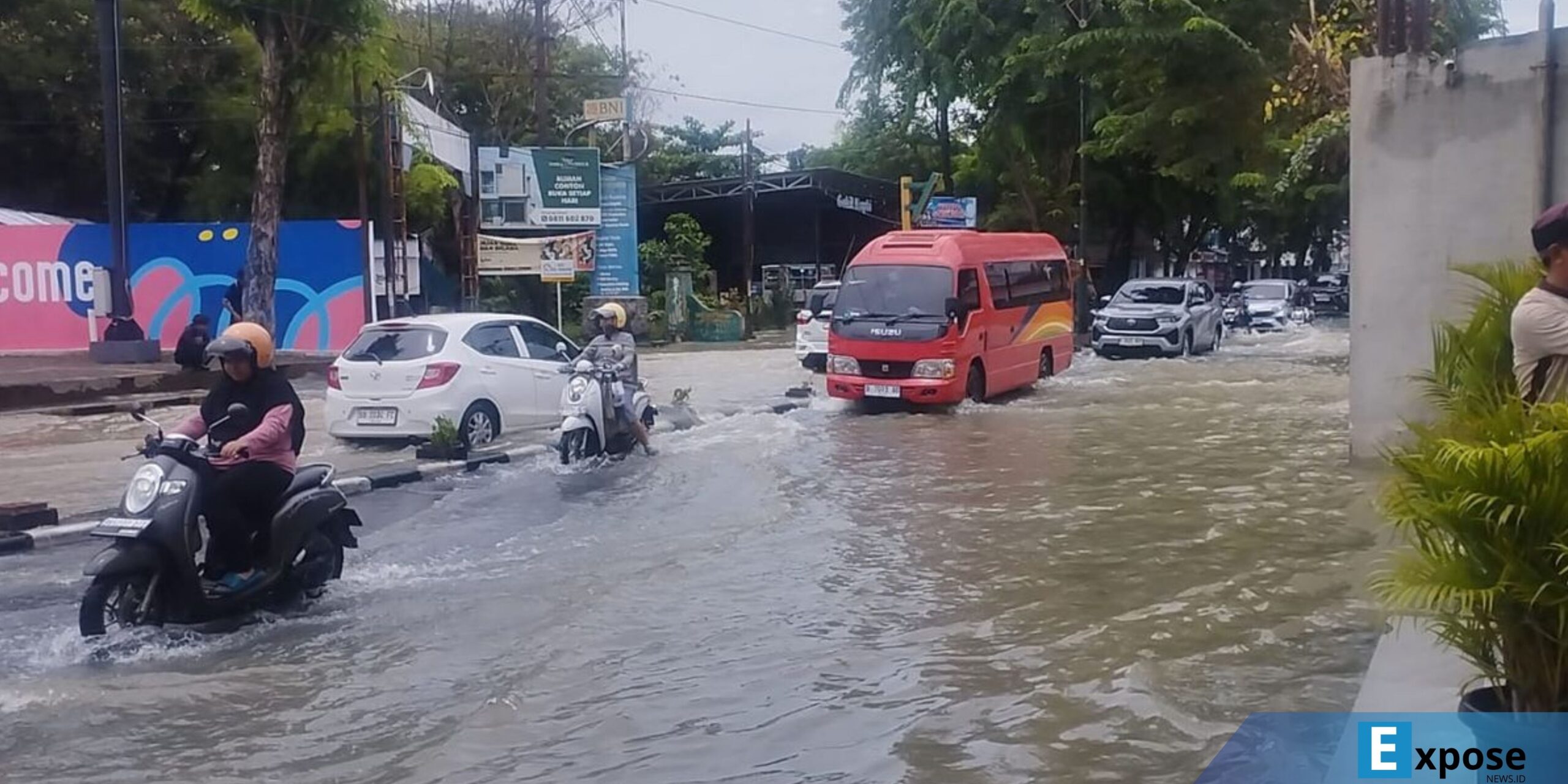 Pengendara terlihat menerobos genangan air yang menutup Jalan Dr. Mansyur, Kelurahan Padangbulan, Kecamatan Medan Selayang